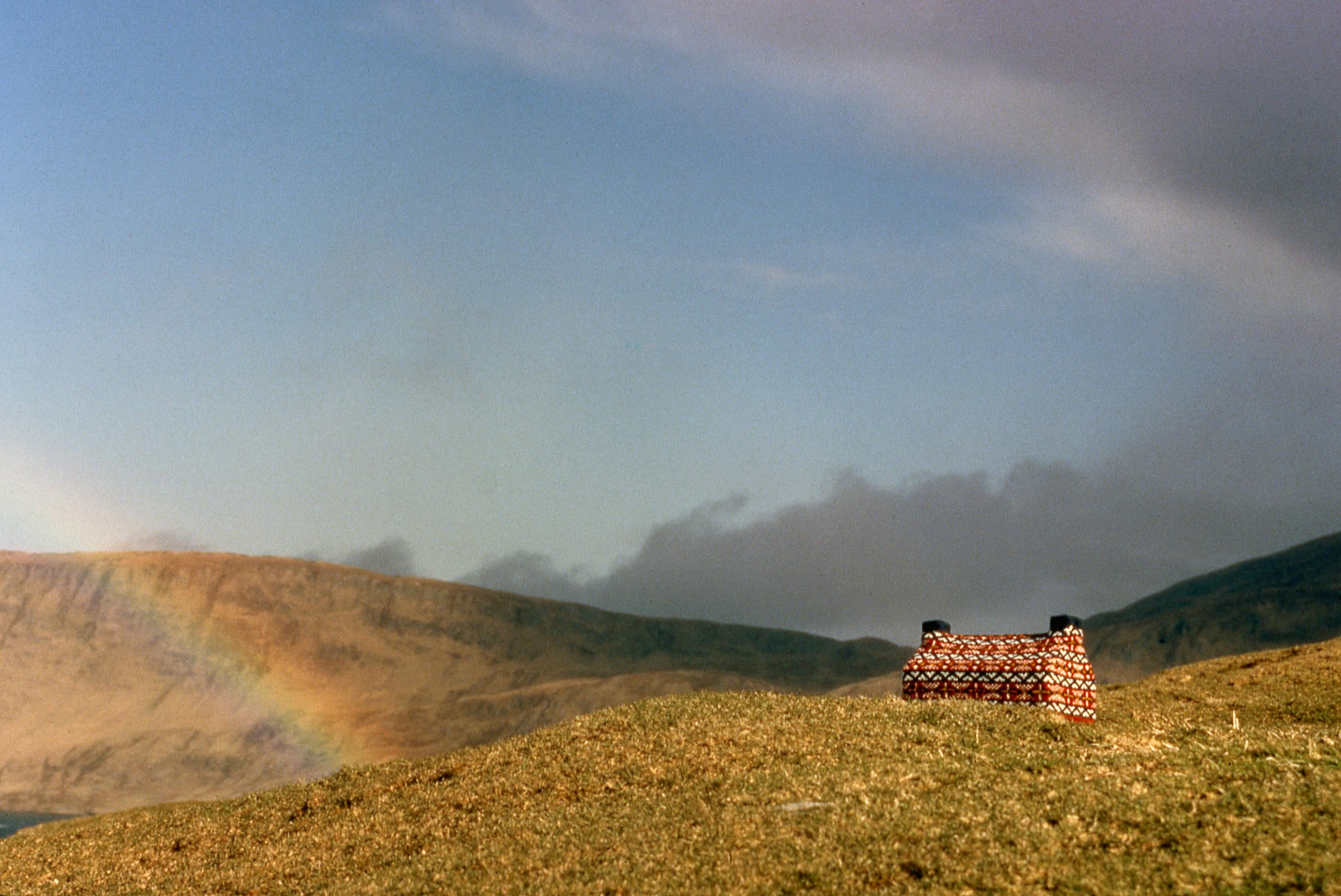 A knitted cabin in a field
