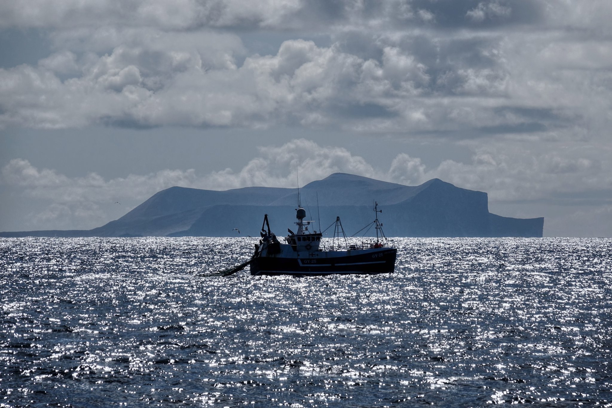A fishing boat next to the island of foula A fishing boat next to the island of foula